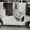 Shirley Temple in front of her bungalow driving a car from Bill Robinson