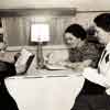 Shirley Temple and teacher Frances Klampt being observed by a member of the L.A. Board of Education in Shirley's dressing room trailer during filming of Just Around The Corner, 1938