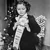 Shirley Temple receiving her Rose Parade Grand Marshal ribbon, November 1938