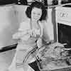 Shirley Temple at her Brentwood home cooking a Thanksgiving turkey, 1941